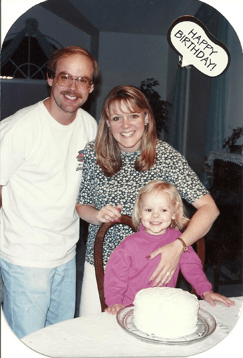 Family gathered around a birthday cake