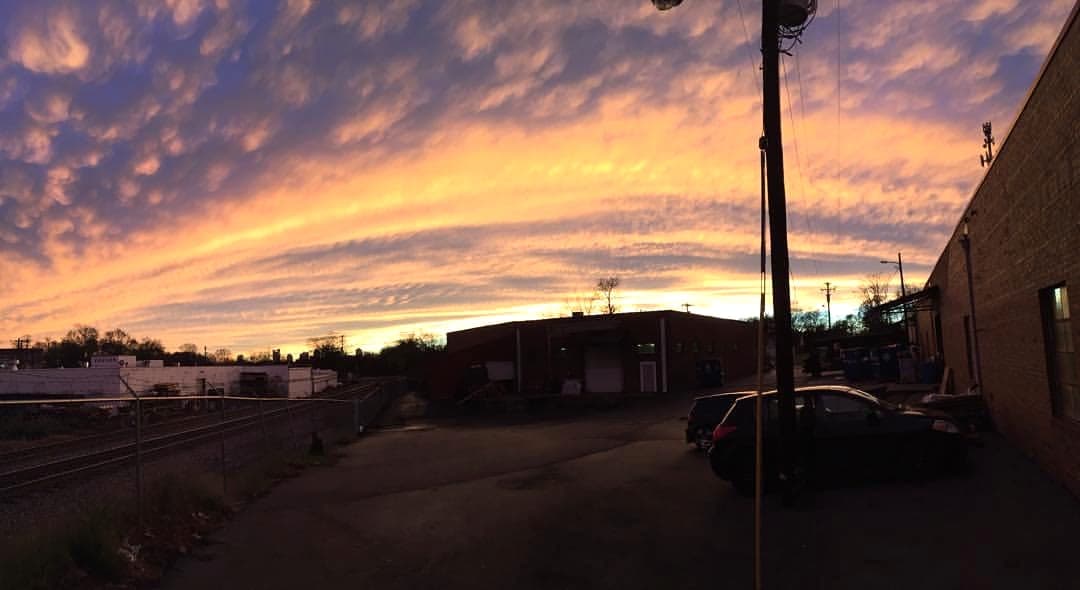 A freight train passes beside the Jewel Street warehouse at sunset.