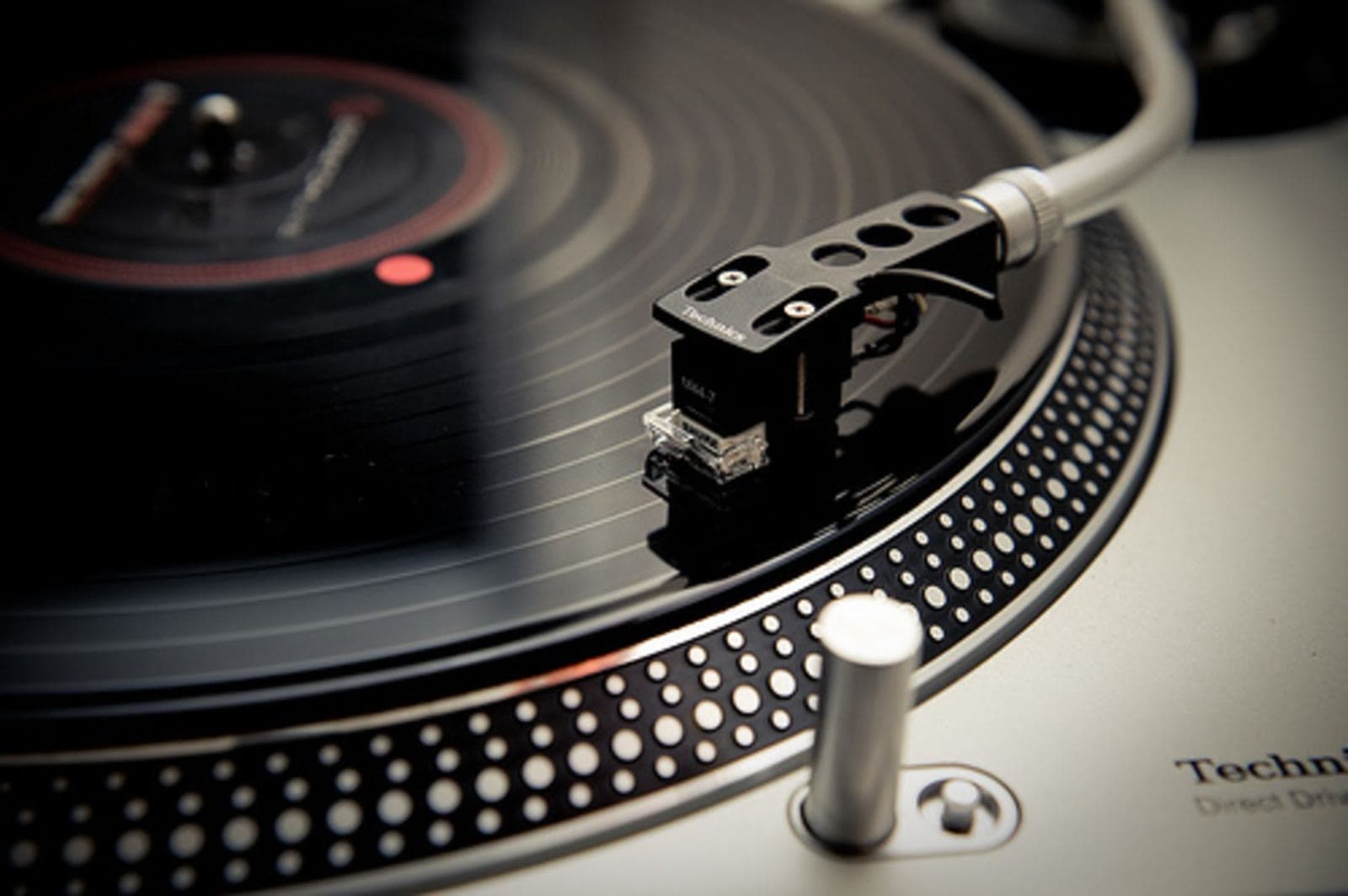 Macro close-up of a turntable stylus riding the groove of a vinyl record