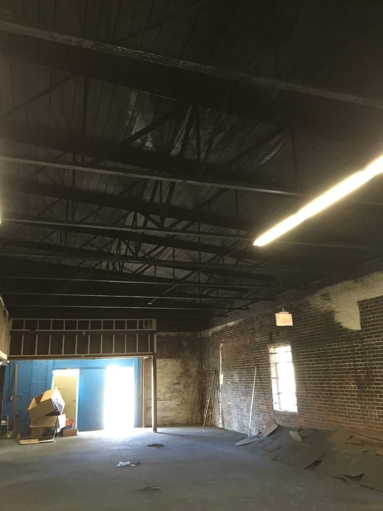 Dark warehouse interior lit by a single doorway